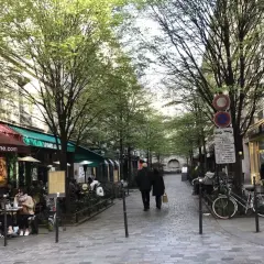 Spacerem w paryskiej dzielnicy Le Marais, z kawiarniami i sklepami po bokach, wczesną wiosną.
