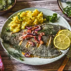 Scholle Finkenwerder Art mit Kartoffelsalat und Gurkensalat, garniert mit Zitrone und Dill.