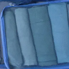 Två blå packpåsar med rullade kläder. Ett perfekt **pile material** för organiserad packning.