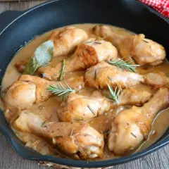 Jamoncitos de pollo guisados en una sartén, con hierbas aromáticas y una salsa cremosa. ¡Un plato casero delicioso!