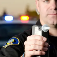 Policjant trzyma alkomat. Nie ma sposobu, jak dmuchać w alkomat żeby nie wykazało.