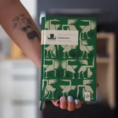 Zielona okładka książki "Mokradła" Marii Turtshaninoff, z ptakami i roślinami, symbolizuje mrok i naturę, przyczyny sukcesu literatury skandynawskiej w Polsce.