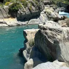 Aguas turquesas fluyen entre rocas erosionadas. Un lugar idílico para leer reseñas de la poza del molino y disfrutar de la naturaleza.