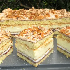 Pyszne ciasto Pani Walewska z kremem i bezą, posypane migdałami. Idealne na deser.