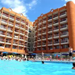 Gente disfrutando en la piscina del hotel Belvedere Salou, con edificios naranjas y blancos de fondo.