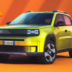 Jaskrawożółty fiat elektryczny z nowoczesnym designem, gotowy na letnią przygodę pod pomarańczowym parasolem.