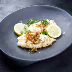 Calamares a la plancha con limón, cubiertos de pan rallado crujiente y hierbas frescas. Un plato ligero y sabroso.