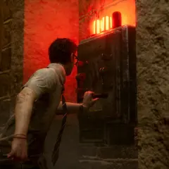 Un survivant ajuste la configuration d'un générateur dans Dead by Daylight, sous une lumière rouge menaçante.