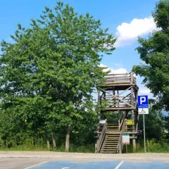 Drewniana wieża widokowa Szczerbanówka z widocznymi schodami i parkingiem.