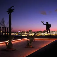 Skulpturer vid ett nytt museum i Stockholm mot en dramatisk kvällshimmel.
