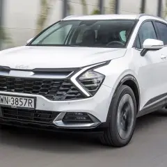Biały Kia Sportage w ruchu. Wiele osób szuka kia sportage opinie, ten model wygląda obiecująco.