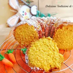 Torta di carote Bimby soffice e profumata, decorata con zucchero a velo e carotine decorative.