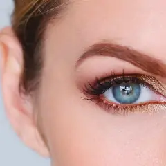 Occhi azzurri esaltati da un trucco dorato e ciglia lunghe.