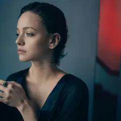 Zamyślona kobieta z kolczykami w uchu i pierścionkiem na palcu. Czy tęsknota oznacza miłość?