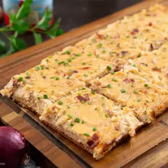 Saftiger Zwiebelkuchen vom Blech, goldbraun gebacken und mit Schnittlauch bestreut. Ein Genuss für jeden Anlass!