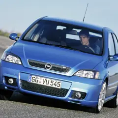 Niebieski Opel Astra G CC z kierowcą na drodze.