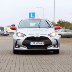 Samochód nauki jazdy z literą "L" na dachu i tablicą "CO ZDAM9". Czy po zdaniu egzaminu na prawo jazdy można jeździć samochodem?