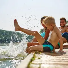 Rodzina pluska się w jeziorze, świetna zabawa na wakacje z nastolatkiem w Polsce.