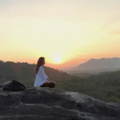 Mujer meditando al amanecer, buscando el equilibrio yin yang en la naturaleza.
