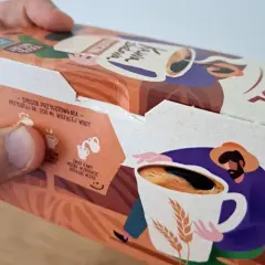 Opakowanie kawy zbożowej Anatol. Na boku instrukcja przygotowania i ilustracja rolnika z kubkiem kawy i kłosami zbóż.