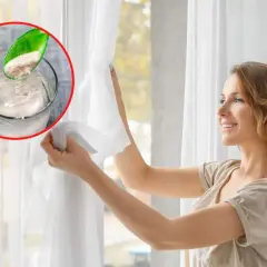 Kobieta przygotowuje się do prania firan. W szklance rozpuszcza proszek, który jest kluczem do tego, w czym moczyć firany przed praniem, by były jak nowe.