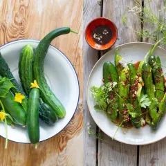 Färska gurkor i en skål och en tallrik med kryddig asiatisk gurksallad, garnerad med örter och blommor.