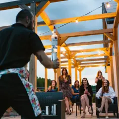 Barman przygotowuje drinki dla grupy kobiet. Świetne, tanie pomysły na wieczór panieński pod gołym niebem.