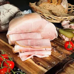Frisch aufgeschnittener Kochschinken, der Lust macht, ihn selber zu machen. Dazu Brot, Tomaten und Gewürzgurken.