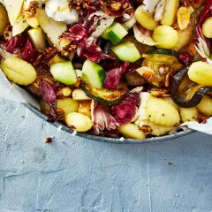 Ein köstlicher lauwarmer Gnocchi-Salat mit gegrilltem Gemüse, Radicchio, Birne und Nüssen, serviert mit Honig.