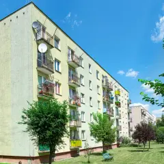 Blok mieszkalny z balkonami i antenami satelitarnymi. Wiesz, jak obliczyć dochód do mieszkania komunalnego?
