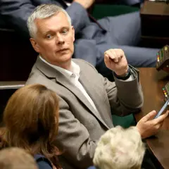 Tomasz Siemoniak, polityk o polskim pochodzeniu, w parlamencie, z telefonem w dłoni.