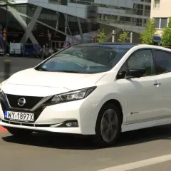 Biały Nissan Leaf 2 jedzie ulicą miasta.