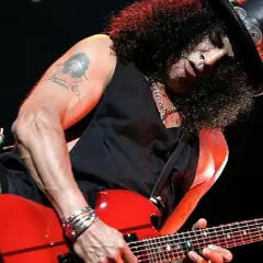 Slash w cylindrze gra na czerwonej gitarze, jakby śpiewał "sweet child o' mine".