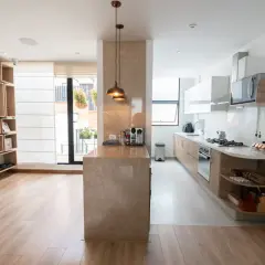Un tabique de cocina semiabierta al salón crea un espacio moderno y funcional.
