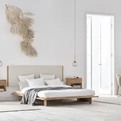 Minimalistisches Schlafzimmer mit einem Bett, Nachttischen und einem Schreibtisch. Die Wand hinterm Bett gestalten Ideen: ein Trockenblumen-Arrangement sorgt für natürliche Akzente.