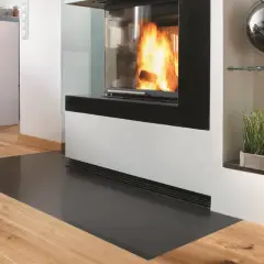 Moderner Kamin mit Sicht auf Flammen, geschützt durch eine Glasplatte. Die Bodenplatte des Ofens entspricht der Vorschrift für Brandschutz.