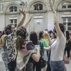 Des gens dansent avec des casques lors d'un concert silencieux devant l'Hôtel de Ville de Paris.