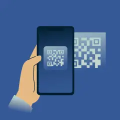 Dłoń trzyma smartfon, na ekranie którego widnieje kod QR. Obok, w tle, kolejny kod QR. Skanowanie telefonu antywirusem online.