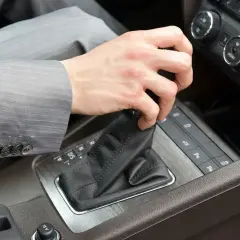 Dłoń w garniturze zmienia bieg w samochodzie z automatyczną skrzynią DSG. Proste wskazówki, jak jeździć automatem DSG.