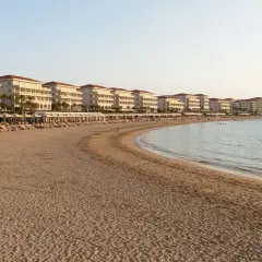 Piękna plaża z rzędami leżaków i białymi hotelami w tle, idealne miejsce na wakacje w Side Colakli.