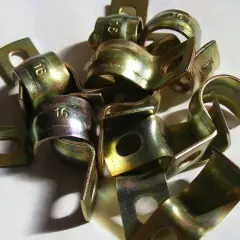 Złote zaciski metalowe, po procesie galwanizacji, z wybitym numerem "16".