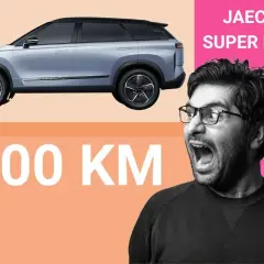 Szary JAECOO 7 SUPER HYBRID z imponującym zasięgiem 1200 km. Mężczyzna z otwartymi ustami wyraża zdumienie.