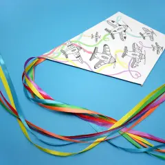 Kolorowy latawiec DIY z rysunkami samolotów i tęczowymi wstążkami.