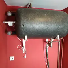 Cieknący zawór bezpieczeństwa przy bojlerze. Widać zielony wąż odprowadzający wodę.