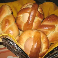 Cuzzupe calabresi morbide, dolci pasquali con uova, in un cestino foderato di giallo.