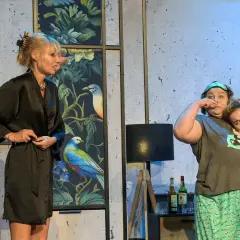 Trzy kobiety w szlafrokach i piżamach na scenie, jedna z nich robi śmieszną minę.