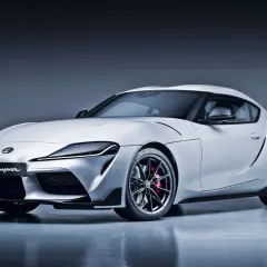 Biała Toyota Supra GR z napisem "GR Supra" na grillu. Ta marka samochodu na zdjęciu to symbol sportowych osiągów.