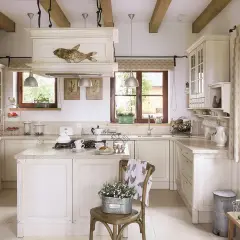Jasna kuchnia w stylu cottage z kamiennym murem, drewnianymi belkami i rustykalnymi dodatkami.