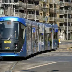 Błękitny tramwaj MPK nr 3006 jedzie po torach. Pytanie "jak dojechać z dworca w krakowie do prokocimia" może być rozwiązane tym środkiem transportu.