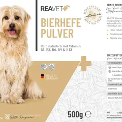 Un chien à poil long et clair, assis, avec un emballage de levure de bière pour chien et chat.